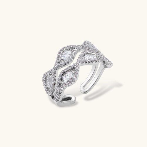 Layered adjustable ring with flowing wave design featuring baguette and round cubic zirconia stones in white gold plating